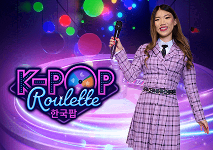 "K-Pop Roulette" с женщиной-ведущей в клетчатом костюме на фоне ярких огней и музыкальных нот.